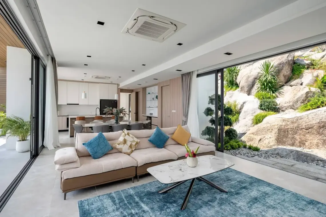 Open-plan living and dining area beside natural granite formations