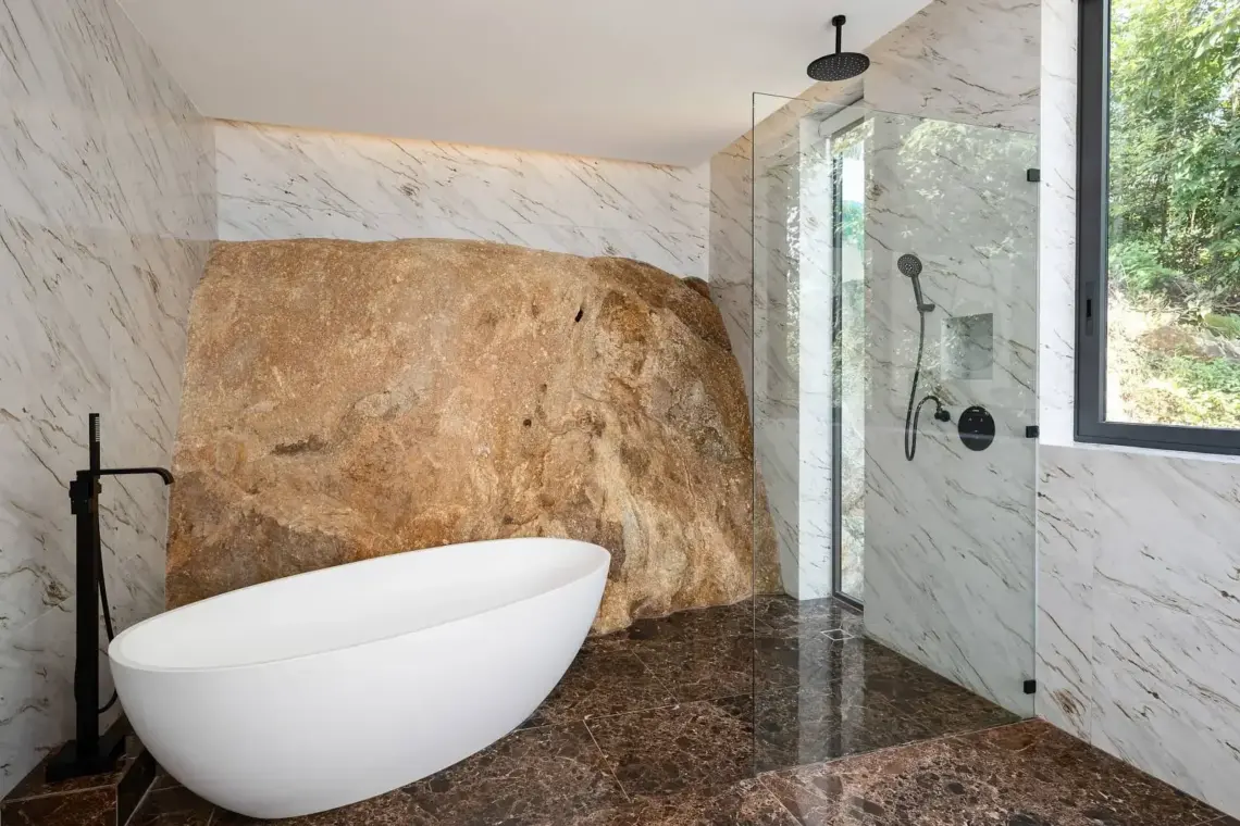 Bathroom with freestanding bathtub beside natural granite in Chaweng Noi villa